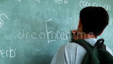 男生在教室黑板上写英语单词